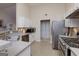 This kitchen features stainless steel appliances, white cabinets, tiled backsplash, and lots of counter space at 4030 Cresent Walk Ne Ln, Suwanee, GA 30024