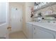 Convenient laundry room featuring a washer, dryer, shelving, and access to the exterior at 4030 Cresent Walk Ne Ln, Suwanee, GA 30024