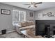 Neutral bedroom featuring a couch, large window with blinds, ceiling fan, and modern decor, creating a cozy space at 5545 Circlestone Ln, Stone Mountain, GA 30083