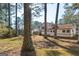 Exterior shot of a two-story house and backyard with pine needles and trees in the background at 9100 Settlers Grove Ne Rd, Covington, GA 30014