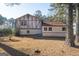 An exterior shot of a two-story home with a lawn covered in pine needles in the backyard at 9100 Settlers Grove Ne Rd, Covington, GA 30014