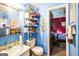 Small bathroom with toilet, sink and shelving unit covered in colorful items, leading to bedroom at 9100 Settlers Grove Ne Rd, Covington, GA 30014