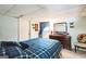 Bedroom with blue plaid comforter, light blue walls, dark dresser, small window and carpet at 9100 Settlers Grove Ne Rd, Covington, GA 30014