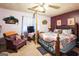 Bedroom with purple walls, a metal frame bed, carpet, TV, and chair with wooden support beam at 9100 Settlers Grove Ne Rd, Covington, GA 30014
