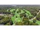 Aerial view of golf course community surrounded by lush trees and a lake in the distance at 310 Westbourne Dr, Tyrone, GA 30290