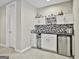 A bar area with modern white cabinetry and eye-catching geometric backsplash and stainless steel beverage cooler at 310 Westbourne Dr, Tyrone, GA 30290