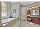 Well-lit bathroom featuring a platform tub, granite countertops, and tiled floor at 310 Westbourne Dr, Tyrone, GA 30290