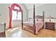 Bedroom features a four poster bed, hardwood floors and a large window with red valance at 310 Westbourne Dr, Tyrone, GA 30290