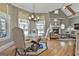 Elegant dining area with chandelier lighting, hardwood floors, and large windows providing ample natural light at 310 Westbourne Dr, Tyrone, GA 30290