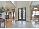 Beautiful foyer featuring stone tile and archway into a dining room with elegant drapery and furnishings at 310 Westbourne Dr, Tyrone, GA 30290