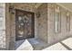 Intricate wrought iron double front doors with decorative wreath, sidelights, and stone and brick accents at 310 Westbourne Dr, Tyrone, GA 30290