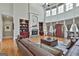 Elegant living room featuring a stone fireplace, built-in shelving, and soaring ceilings with large windows at 310 Westbourne Dr, Tyrone, GA 30290