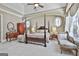 Spacious main bedroom featuring a four-poster bed, round windows, and comfortable seating area, exuding elegance at 310 Westbourne Dr, Tyrone, GA 30290