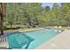 Relaxing pool area with a pergola covered lounge and hot tub surrounded by lush greenery at 310 Westbourne Dr, Tyrone, GA 30290