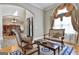 Sitting room with hardwood floors and archway view into a dining room with luxury decor and lighting at 310 Westbourne Dr, Tyrone, GA 30290