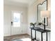 A welcoming entryway with a console table, lamp, and large mirror reflecting natural light at 10453 Trellis Lane (Lot 28), Hampton, GA 30228