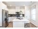 Bright kitchen boasts white cabinetry, stainless steel appliances, and a center island with quartz countertop at 10453 Trellis Lane (Lot 28), Hampton, GA 30228