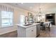 Kitchen with an island, stainless appliances and white cabinets open to living and dinning area at 10453 Trellis Lane (Lot 28), Hampton, GA 30228