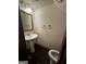Powder room featuring a pedestal sink, mirror, towel rings, and toilet with dark wood flooring at 120 Wayside Dr, Lawrenceville, GA 30046