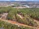 Beautiful aerial view of a home nestled in a wooded area, with a serene lake nearby at 180 Collins Way, Locust Grove, GA 30248