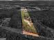 Aerial view showcasing the home's location on a spacious lot surrounded by lush trees and a lake at 180 Collins Way, Locust Grove, GA 30248