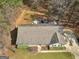 Aerial view of the home showcasing the roof, driveway, and surrounding wooded area at 180 Collins Way, Locust Grove, GA 30248