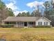 Charming single-story home with a welcoming front porch and well-maintained landscaping at 180 Collins Way, Locust Grove, GA 30248