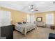 Main bedroom with neutral carpet, lighted ceiling fan and sunny windows at 180 Collins Way, Locust Grove, GA 30248