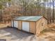 Aerial view of the outbuilding showing the color, metal roof, and two garage doors at 180 Collins Way, Locust Grove, GA 30248