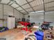 The interior of the outbuilding shows tools, motorcycle, shelving, and workspace at 180 Collins Way, Locust Grove, GA 30248