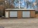 Exterior view of an outbuilding with two garage doors and a side entrance at 180 Collins Way, Locust Grove, GA 30248