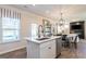 Kitchen island with stainless steel dishwasher, light countertops and view to the living room at 10410 Trellis Lane (Lot 35), Hampton, GA 30228