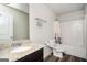 Cozy bathroom with granite countertop sink, toilet, shower and white and floral-patterned curtain at 220 Long Dr, Mcdonough, GA 30253