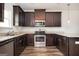 This kitchen features dark wood cabinetry, stainless steel appliances, and granite countertops at 220 Long Dr, Mcdonough, GA 30253