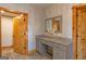 Bathroom vanity features a gray countertop and a mirror, positioned between two wood doors at 5735 Archer Ave, Cumming, GA 30041