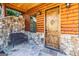 Inviting front porch with stone accents, wood door, and decorative lighting at 5735 Archer Ave, Cumming, GA 30041