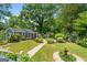 Lovely backyard garden featuring a stone path, mature trees, and lush landscaping at 35 W Main St, Hampton, GA 30228