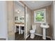 Cozy bathroom featuring a pedestal sink, toilet, and stylish wood-paneled walls, accessed via a rustic door at 35 W Main St, Hampton, GA 30228