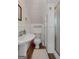 Small bathroom with a white sink, toilet and shower unit with wood-look floors at 35 W Main St, Hampton, GA 30228