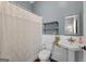 Cozy bathroom featuring a shower with lace curtain, a pedestal sink and wood-look flooring at 35 W Main St, Hampton, GA 30228