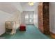 Bright bedroom features a brick chimney, a ceiling fan, and blue carpeted floors at 35 W Main St, Hampton, GA 30228