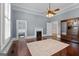 Spacious bedroom with hardwood floors, fireplace, ceiling fan, and large wardrobe cabinet at 35 W Main St, Hampton, GA 30228