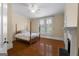 Bedroom with a four-poster bed, hardwood floors, fireplace, and shuttered windows at 35 W Main St, Hampton, GA 30228