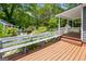 Inviting wooden deck with a built-in bench overlooks the lush landscaped backyard at 35 W Main St, Hampton, GA 30228