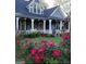 Charming two-story home with a welcoming front porch and beautiful flowers in the garden at 35 W Main St, Hampton, GA 30228