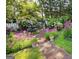Tranquil garden featuring a stone path, a fountain with a statue, and beautiful flowering plants at 35 W Main St, Hampton, GA 30228