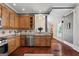 Kitchen with wood cabinets, view to an adjacent light-filled dining space with vaulted ceiling and large window at 35 W Main St, Hampton, GA 30228