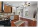 Traditional kitchen features wood cabinets, stainless steel dishwasher, and adjacent dining area with hardwood floors at 35 W Main St, Hampton, GA 30228