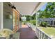 Cozy porch with orange french doors, wicker chair, and view of the garden at 35 W Main St, Hampton, GA 30228