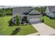 Well-maintained gray home featuring a two-car garage, grassy yard, and inviting front entrance at 104 Conway St, Peachtree City, GA 30269